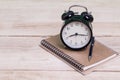 Old fashion alarm clock and book with pen on table Royalty Free Stock Photo