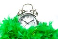 Old fashioned alarm clock wearing a green boa over white Royalty Free Stock Photo