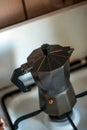 An old-fashioned aluminum geyser coffee maker is standing on the stove. Royalty Free Stock Photo