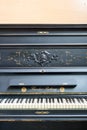 Old-fashioned antique ornamental piano with carved pillars. After restoration