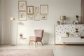 Old-fashioned armchair, pastel pink floor lamp and stylish, gold Royalty Free Stock Photo