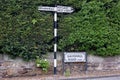 Old fashioned black and white direction signs next to modern street sign Saughall Massie Wirral May 2020 Royalty Free Stock Photo