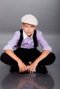 Old fashioned boy sitting on gray background Royalty Free Stock Photo