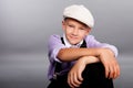 Old fashioned boy sitting on gray background Royalty Free Stock Photo