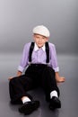 Old fashioned boy sitting on gray background Royalty Free Stock Photo