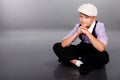 Old fashioned boy sitting on gray background Royalty Free Stock Photo