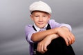 Old fashioned boy sitting on gray background Royalty Free Stock Photo