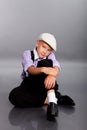 Old fashioned boy sitting on gray background Royalty Free Stock Photo