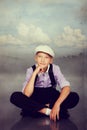 Old fashioned boy sitting. Photo in retro style.