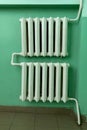 Old-fashioned cast iron water radiator with pipes in hallway or living room in soviet union style. Heating building home of winter Royalty Free Stock Photo