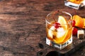 Old Fashioned - classic alcoholic cocktail with bourbon whiskey, bitter, cane sugar and ice in retro glasses on vintage bar