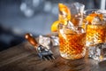 Old fashioned classic rum cocktail on ice with orange zest garnish