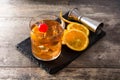 Old fashioned cocktail with orange and cherry on wooden table