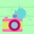 The old-fashioned color camera. Flat style. on a wooden background Royalty Free Stock Photo