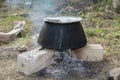 Old fashioned cooking stove with metal steel pans on a fire. Cooking food by scout at camping scout . the water evaporates from Royalty Free Stock Photo