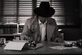 Old fashioned detective at table in office. Black and white effect Royalty Free Stock Photo