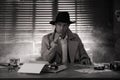 Old fashioned detective at table in office. Black and white effect Royalty Free Stock Photo