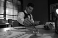 Old fashioned detective working at table in office, focus on hand with ink pen. Black and white effect Royalty Free Stock Photo