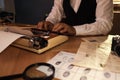 Old fashioned detective working with typewriter at table in office Royalty Free Stock Photo