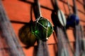 Fishing net with colorful glass balls and bobbers hanging on a red wall Royalty Free Stock Photo