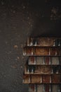 Old fashioned flat lay with stack of antique leather bound books against a dark background