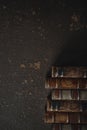 Old fashioned flat lay with stack of antique leather bound books against a dark background Royalty Free Stock Photo