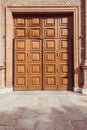 Old fashioned front double doors, all in dark brown colors. Beautiful stone door platband and wooden panels on doors Royalty Free Stock Photo