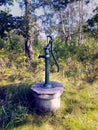 An old fashioned hand powered water pump in garden Royalty Free Stock Photo