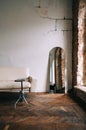 Old fashioned interior big wooden window and mirror, white sofa in old vintage living room with brick walls Royalty Free Stock Photo