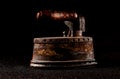 An old fashioned iron with a wooden handle sits on a black background Royalty Free Stock Photo