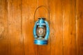 Old fashioned lantern with flame on a brown wooden wall Royalty Free Stock Photo