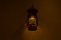 Old fashioned lantern with flame on a brown wooden wall Royalty Free Stock Photo