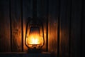 Old fashioned lantern with flame on a wooden wall Royalty Free Stock Photo