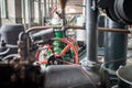 Old fashioned machinery in an old factory interior. Industrial engines. Pipes, gears and valves and other parts Royalty Free Stock Photo