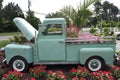 The old fashioned mini-truck is a unique way to display the flowers and plants.