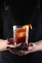 Old fashioned Negroni cocktail in hand on the black background Royalty Free Stock Photo