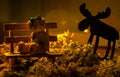 Old fashioned photo with a cute teddy bear and moose figure in a romantic light in a forest environment