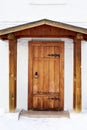 An old-fashioned porch and a wooden door set in a white brick wall Royalty Free Stock Photo