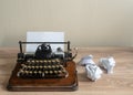 Old antique portable typewriter with screwed up paper on desk Royalty Free Stock Photo