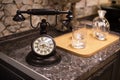 Old fashioned retro dark brown metal telephone with clear glasses on marble table