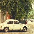 Old-fashioned retro small car parked on the street of european town Royalty Free Stock Photo