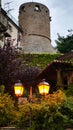 An old fashioned street lamp near the castle wall with a tower in the evening. An ancient lantern illuminates the Royalty Free Stock Photo