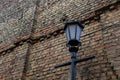 Old-fashioned street lantern in front of the old brick wall