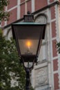 Old fashioned street light on at dusk.