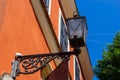 Old-fashioned street wall lamp made of black metal. Gray facade of an old house with a window and a wooden frame. Lviv, Ukraine Royalty Free Stock Photo