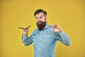 From old-fashioned to hipster chic. Hipster hold shaving tools yellow background. Professional barber wear long beard