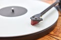 Old-fashioned turnable record player on a wooden background.