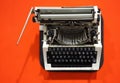 Old-fashioned typewriter on a bright orange background