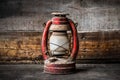 Old fashioned vintage kerosene oil lantern lamp burning with a soft glow light with aged wooden floor Royalty Free Stock Photo