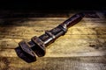 Old fashioned, vintage pipe wrench on a rustic wooden background.